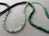 closeup of gemstone bead necklace comprising green prehnite, teal aventurine and exotic wood