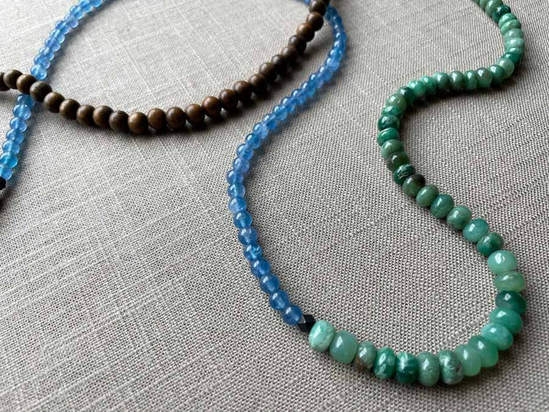 closeup of gemstone bead necklace comprising blue apatite, green aventurine and exotic wood