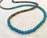 closeup of gemstone bead necklace comprising aqua iolite, bronze hematite and green labradorite