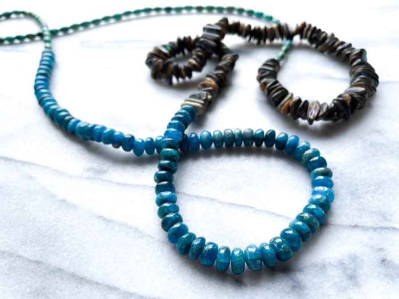 closeup of gemstone bead necklace comprising turquoise, blue apatite and Tahitian shell