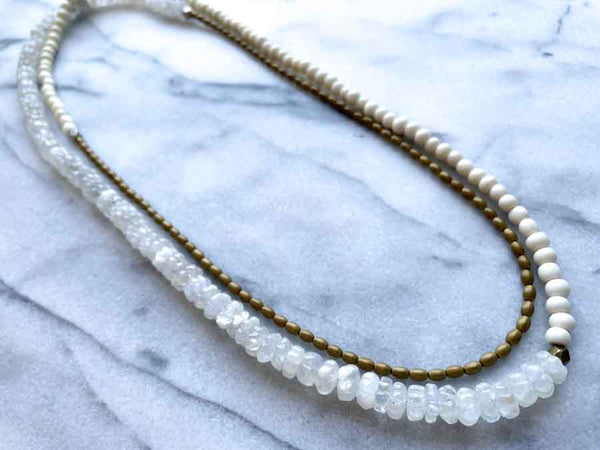 top view of gemstone bead necklace comprising white moonstone, conch shell and bronze