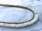 side view of gemstone bead necklace comprising white moonstone, conch shell and bronze