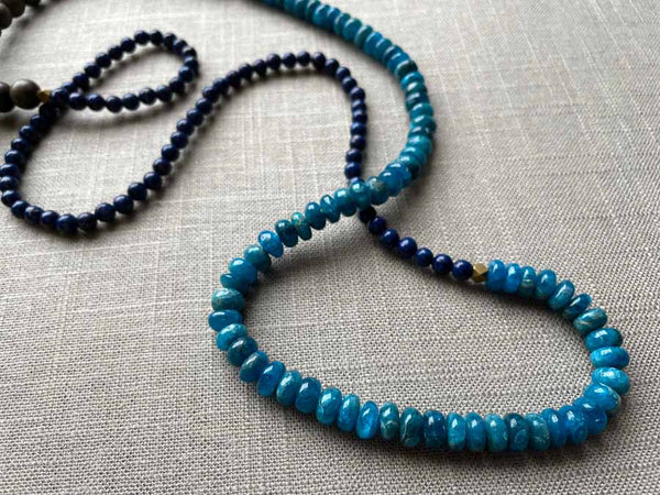 closeup of gemstone bead necklace comprising blue apatite, dark blue lapis and exotic wood