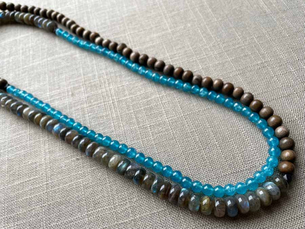 top view of gemstone bead necklace comprising blue apatite, blue labradorite and exotic wood