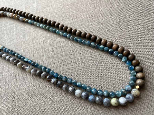 top view of gemstone bead necklace comprising blue kyanite, neutral dendritic opal and exotic wood