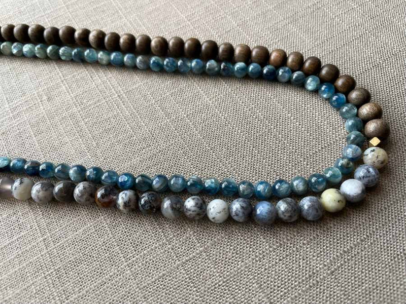 side view of gemstone bead necklace comprising blue kyanite, neutral dendritic opal and exotic wood