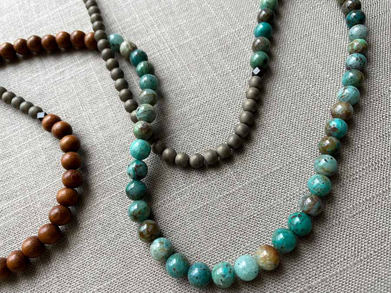 closeup of gemstone bead necklace comprising blue chrysoprase, bronze and exotic wood