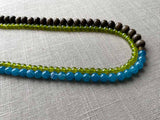 side view of gemstone bead necklace comprising blue apatite, green peridot and exotic wood