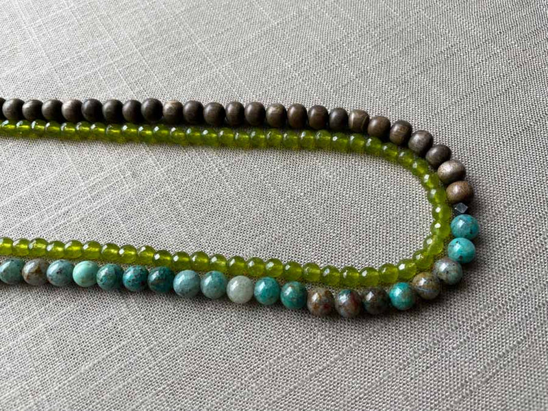 side view of gemstone bead necklace comprising blue chrysoprase, green peridot and exotic wood