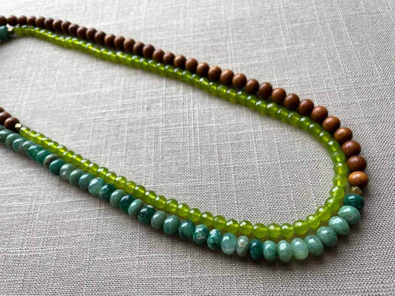 top view of gemstone bead necklace comprising teal aventurine, green peridot and exotic wood