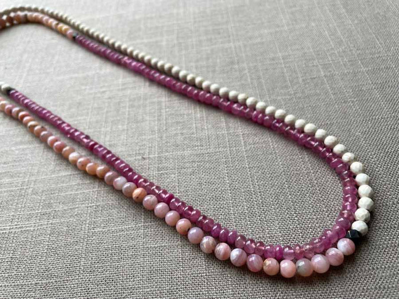 top view of gemstone bead necklace comprising pink opal, pink sapphire and white turquoise