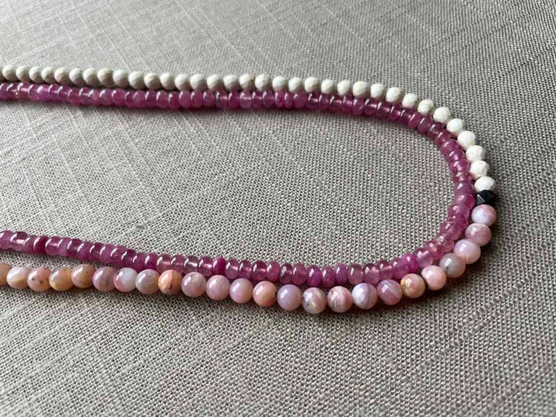 side view of gemstone bead necklace comprising pink opal, pink sapphire and white turquoise