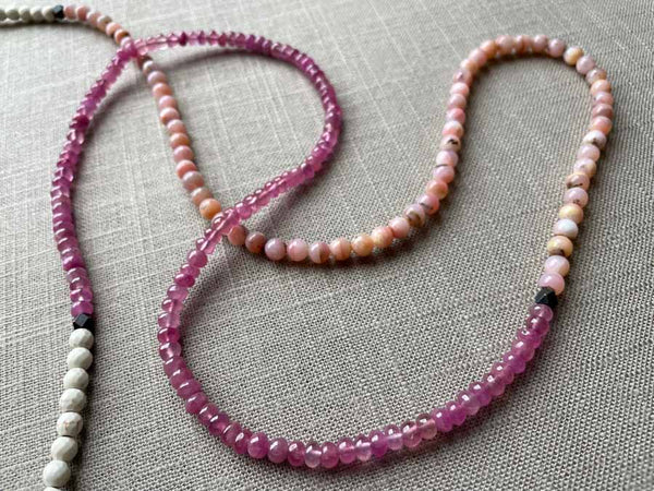 closeup of gemstone bead necklace comprising pink opal, pink sapphire and white turquoise