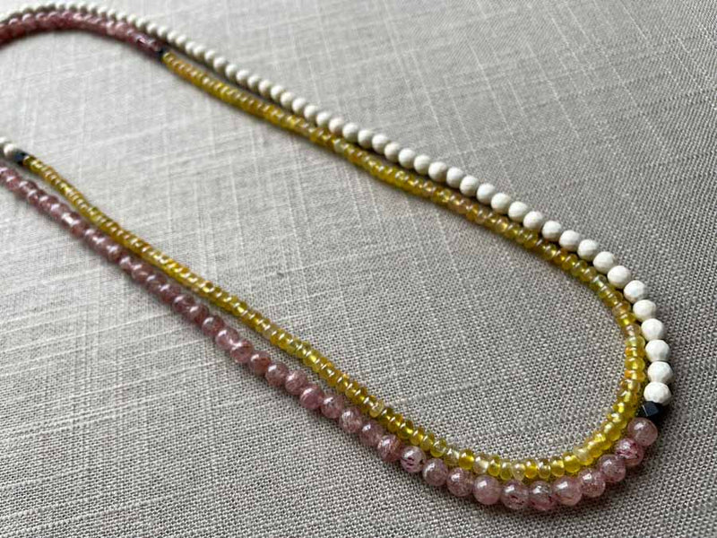 top view of gemstone bead necklace comprising pink strawberry quartz, yellow sapphire and white turquoise