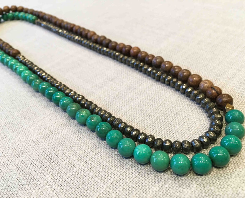 top view of gemstone bead necklace comprising turquoise, dark grey pyrite and exotic wood