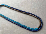 top view of gemstone bead necklace comprising blue apatite, blue sapphire and exotic wood