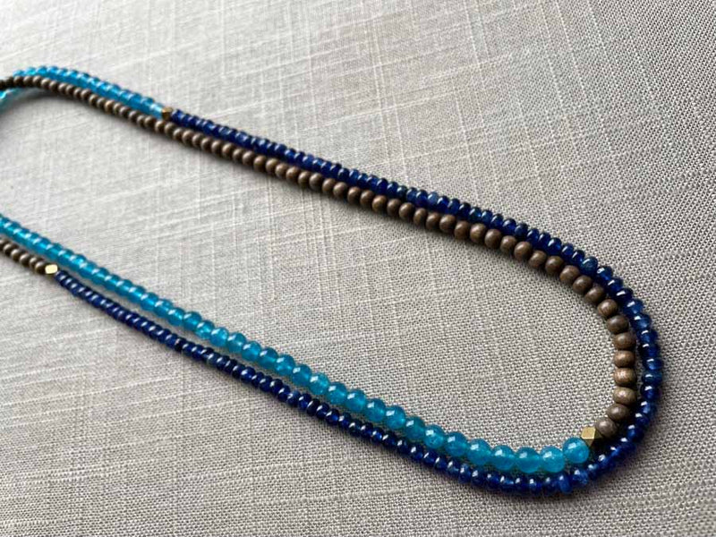 top view of gemstone bead necklace comprising blue apatite, blue sapphire and exotic wood