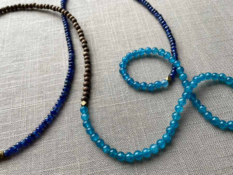 closeup of gemstone bead necklace comprising blue apatite, blue sapphire and exotic wood