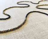 closeup of gemstone bead necklace comprising golden pyrite and dark bronze