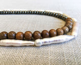 Side view of gemstone bead necklace comprising white stick pearl, pyrite and exotic wood.