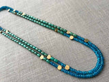 top view of gemstone bead necklace comprising turquoise, blue iolite and bronze dot accents