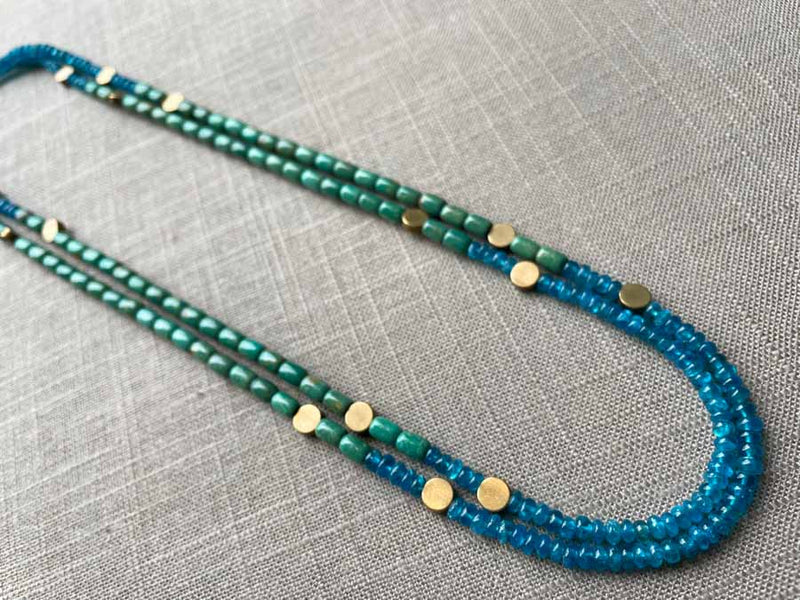 top view of gemstone bead necklace comprising turquoise, blue iolite and bronze dot accents