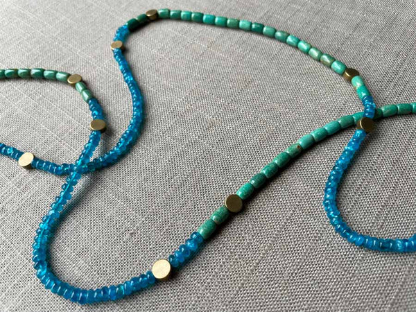 closeup of gemstone bead necklace comprising turquoise, blue iolite and bronze dot accents