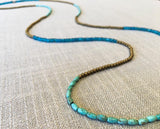 closeup of gemstone bead necklace comprising blue apatite, gold hematite and turquoise