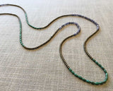 closeup of gemstone bead necklace comprising blue denim quartz, light gold hematite and turquoise