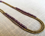 top view of gemstone bead necklace comprising pink pearl, gold hematite and dark pink charoite