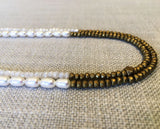 side view of gemstone bead necklace comprising white pearl, gold hematite and white moonstone