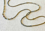 closeup of gemstone bead necklace comprising shell, moonstone, pyrite and hematite