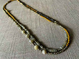 top view of gemstone bead necklace comprising labradorite, raw pyrite, dark bronze and gold hematite