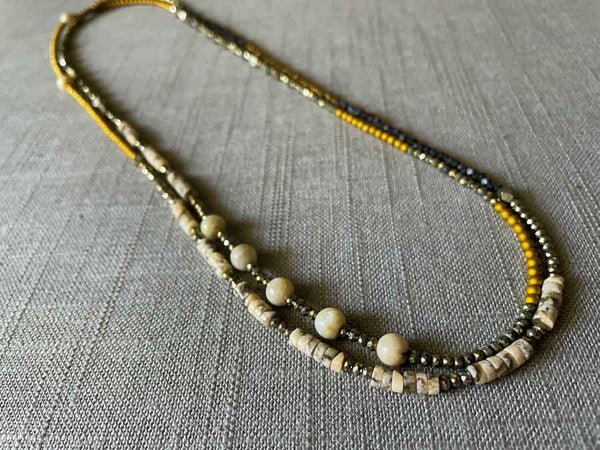 top view of gemstone bead necklace comprising neutral feldspar, raw pyrite, dark bronze and gold hematite