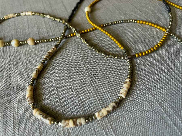 closeup of gemstone bead necklace comprising neutral feldspar, raw pyrite, dark bronze and gold hematite