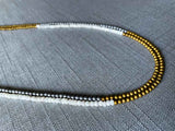 side view of gemstone bead necklace comprising white moonstone, silver and gold hematite