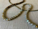 closeup of gemstone bead necklace comprising labradorite, dark grey pyrite and exotic wood