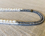 side view of gemstone bead necklace comprising white pearl, silver hematite and white moonstone