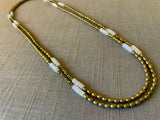 top view of gemstone bead necklace comprising white quartz, light gold hematite and golden pyrite