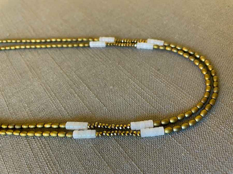 side view of gemstone bead necklace comprising white quartz, light gold hematite and golden pyrite