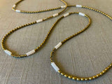 closeup of gemstone bead necklace comprising white quartz, light gold hematite and golden pyrite