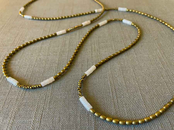 closeup of gemstone bead necklace comprising white quartz, light gold hematite and golden pyrite