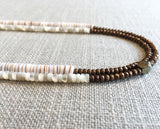 side view of gemstone bead necklace comprising white mother of pearl, bronze hematite and white shell