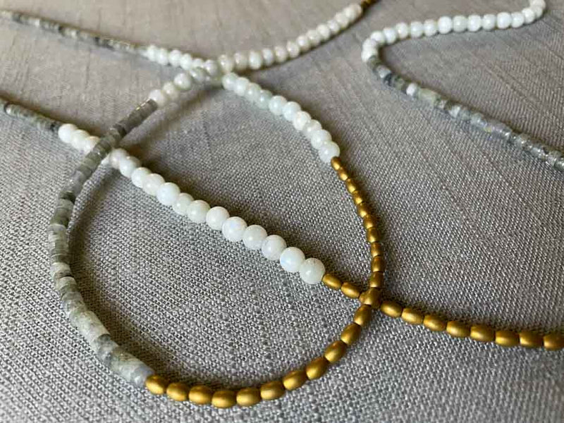 closeup of gemstone bead necklace comprising labradorite, off-white siberian moonstone and gold hematite