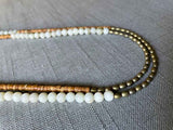 side view  of gemstone bead necklace comprising golden feldspar, off-white siberian moonstone and light gold hematite