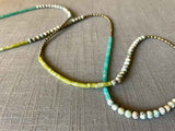 closeupof gemstone bead necklace comprising white k2 granite, green jade, blue amazonite and light gold hematite