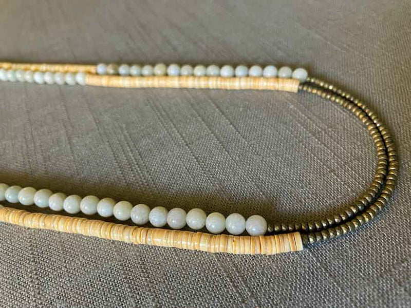 side view of gemstone bead necklace comprising white siberian moonstone, cream shell and light gold hematite