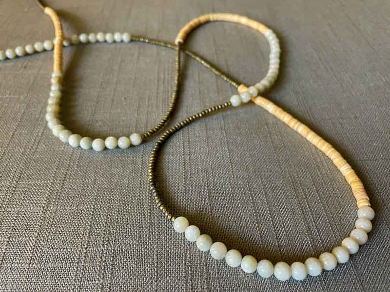 closeup of gemstone bead necklace comprising white siberian moonstone, cream shell and light gold hematite