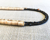 side view of gemstone bead necklace comprising tan mother of pearl, bronze hematite and white shell