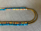 side view of gemstone bead necklace comprising multicolored vinyl discs, blue apatite and gold hematite